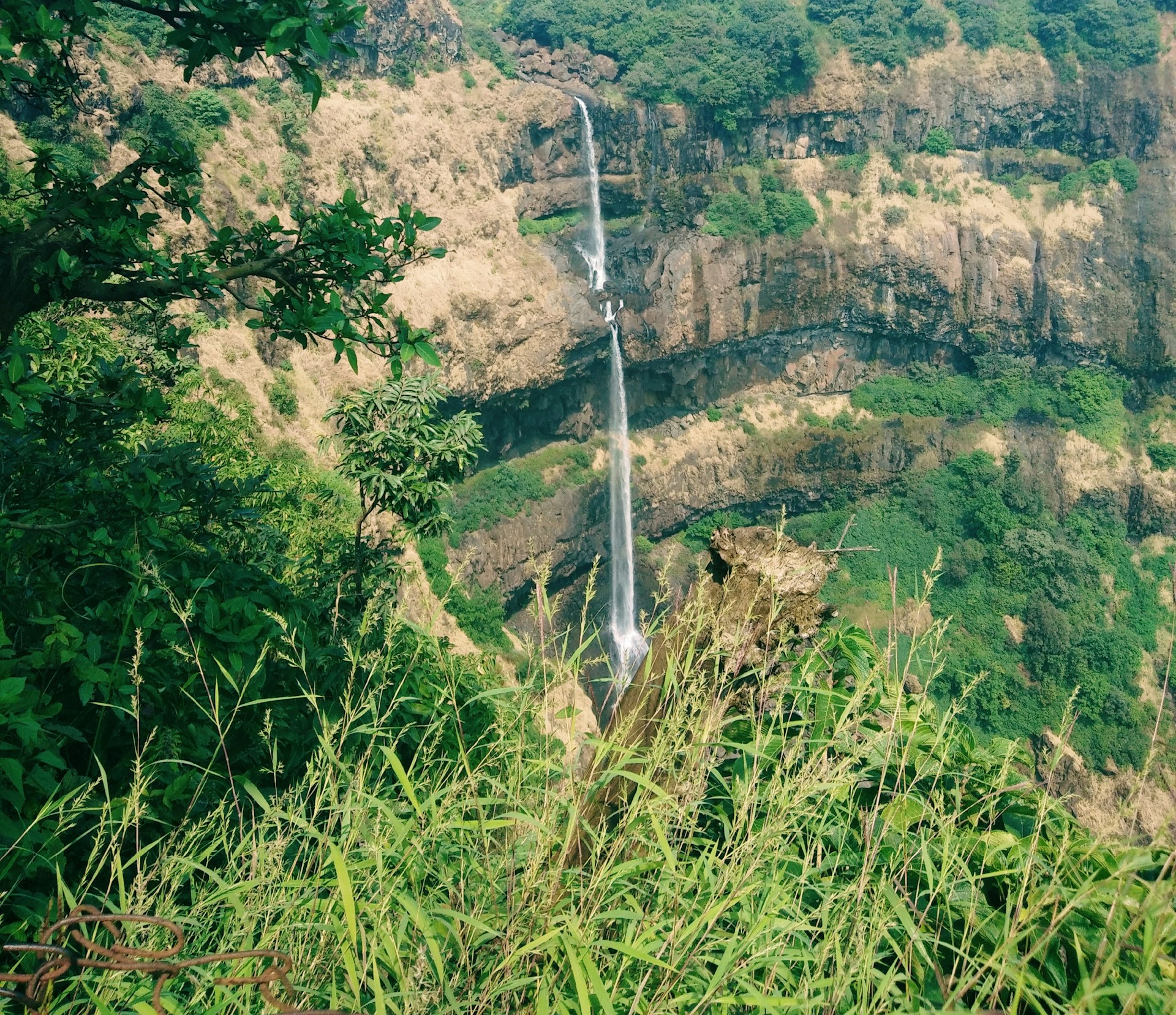 a waterfall in the middle of a lush green valley
